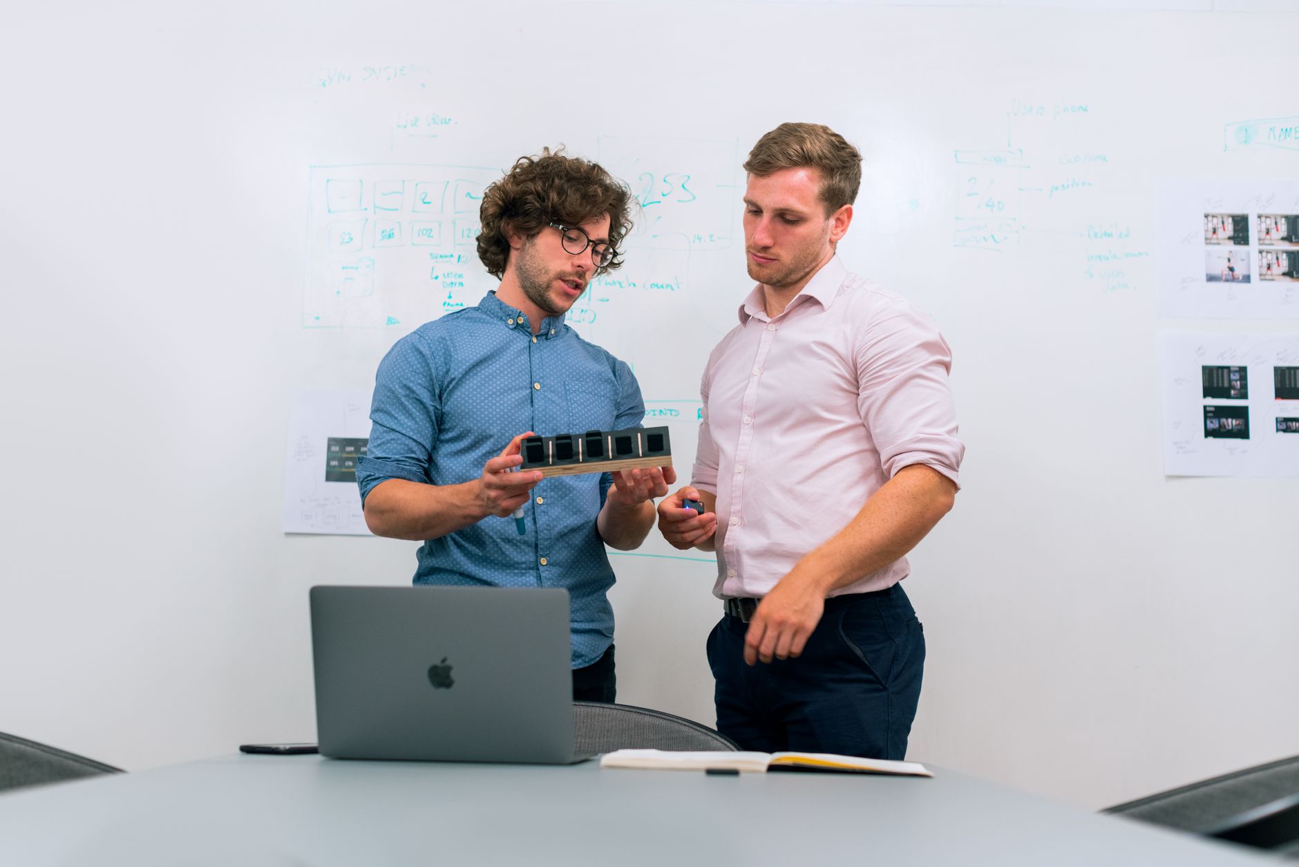 Group of engineers in hard hats reviewing building blueprints in a modern office